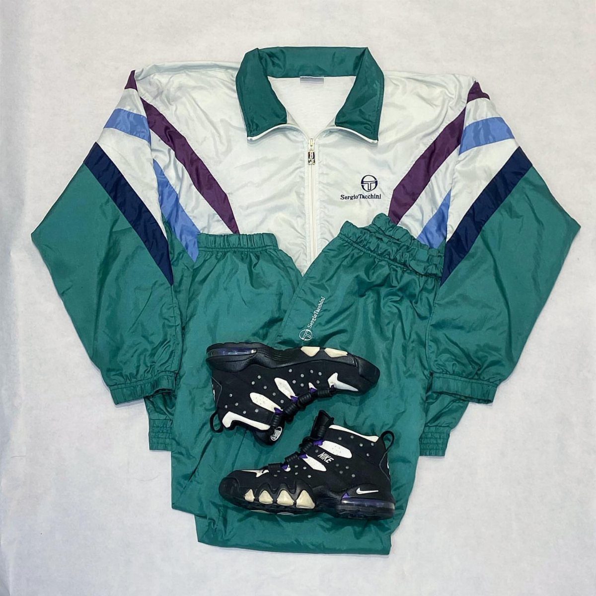 A teal and white vintage tracksuit with matching pants and black high-top sneakers.
