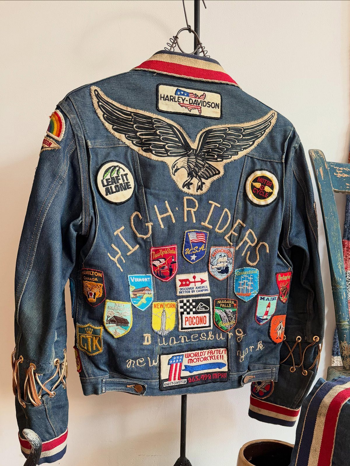 A blue denim jacket covered in various colorful embroidered patches and a large eagle design.