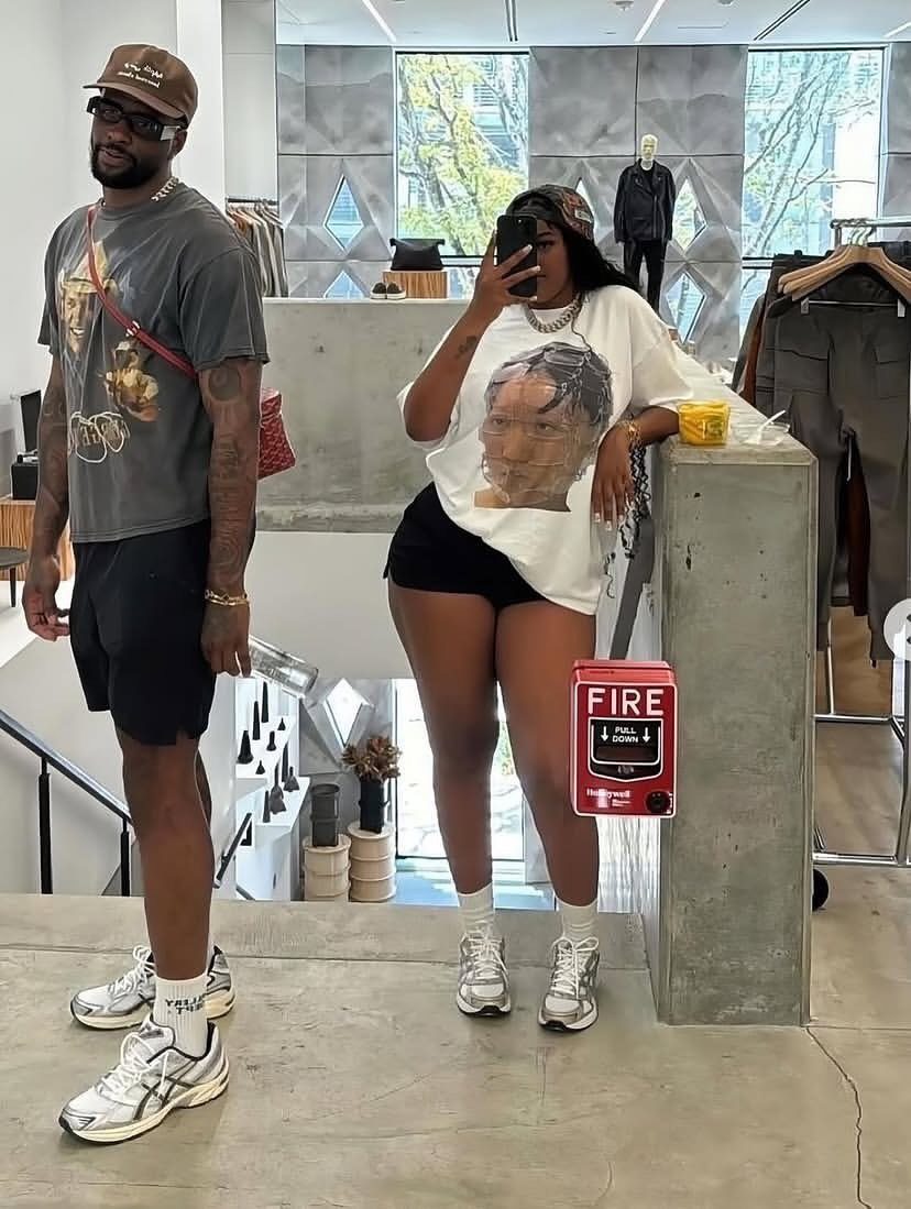 Man and woman posing in casual streetwear with white athletic sneakers in a bright clothing store.