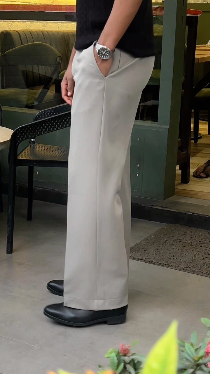 Person wearing light grey wide-leg dress pants and black leather Chelsea boots.