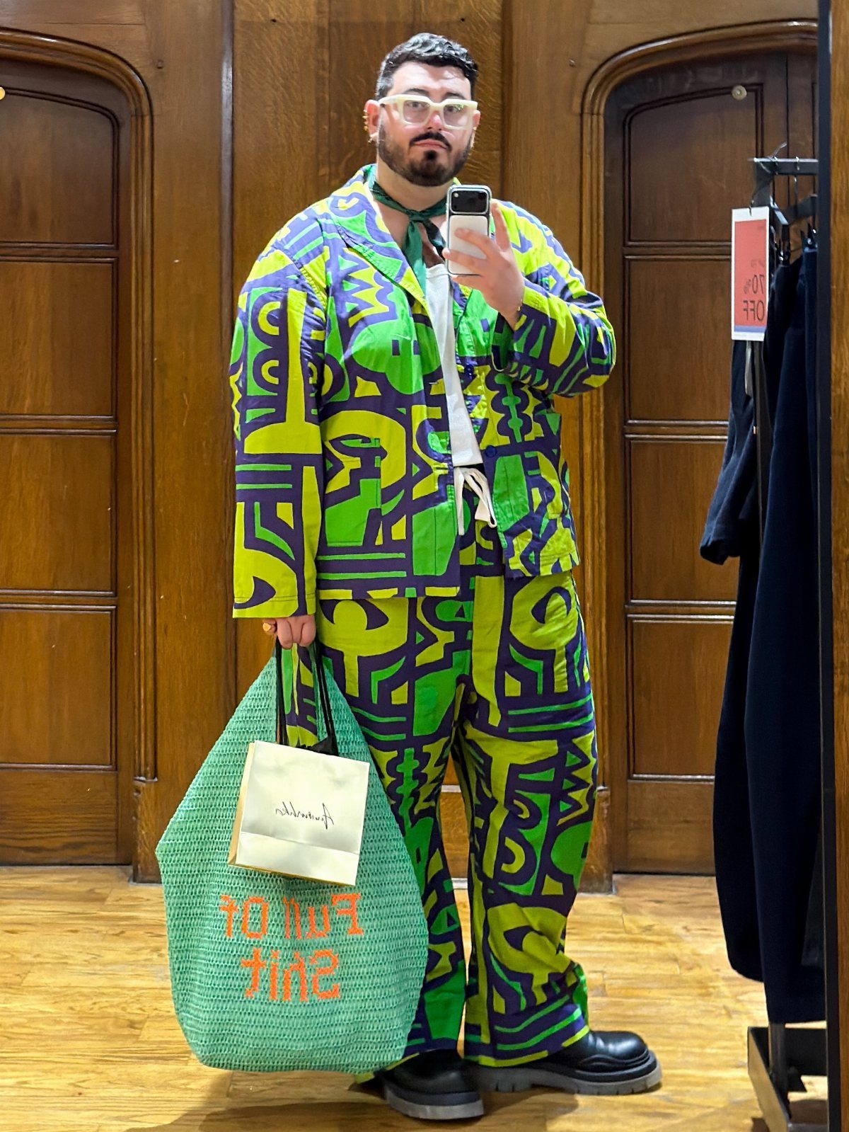 Person wearing a vibrant green and purple patterned matching jacket and trousers set.