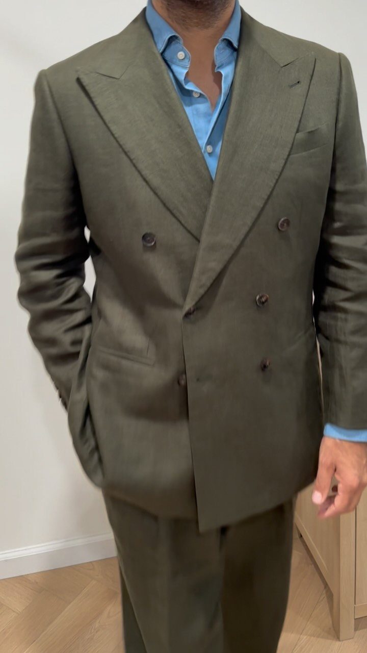 Man wearing a double-breasted olive green suit with a light blue shirt.