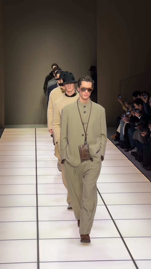 Models walking a runway wearing high fashion beige monochromatic outfits and sunglasses.