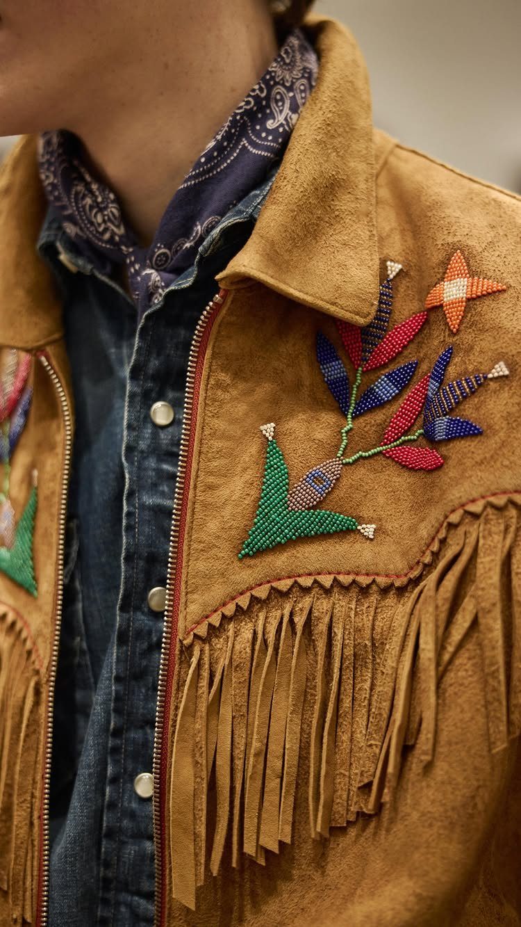 Tan suede fringe jacket with colorful beaded floral embroidery worn over a denim shirt and bandana.