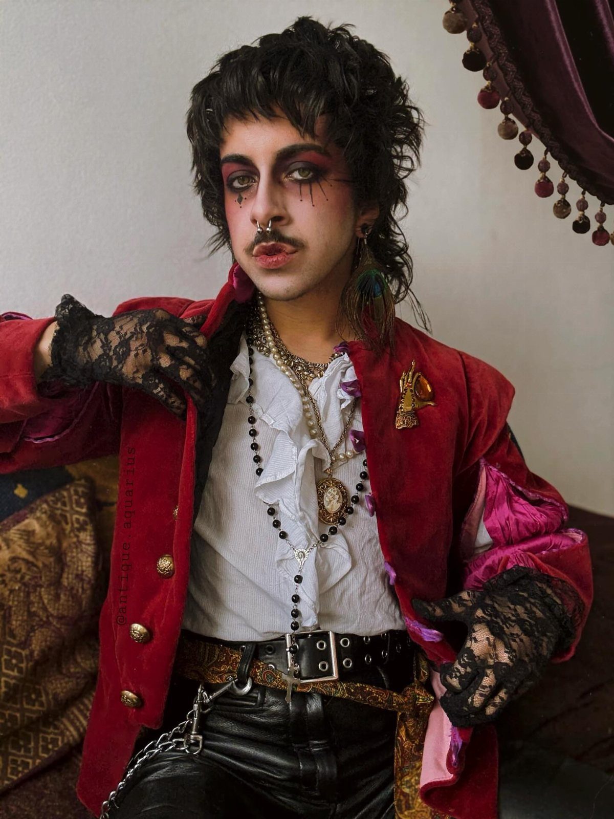 Person in New Romantic style wearing red velvet, frilled shirt, and lace gloves.