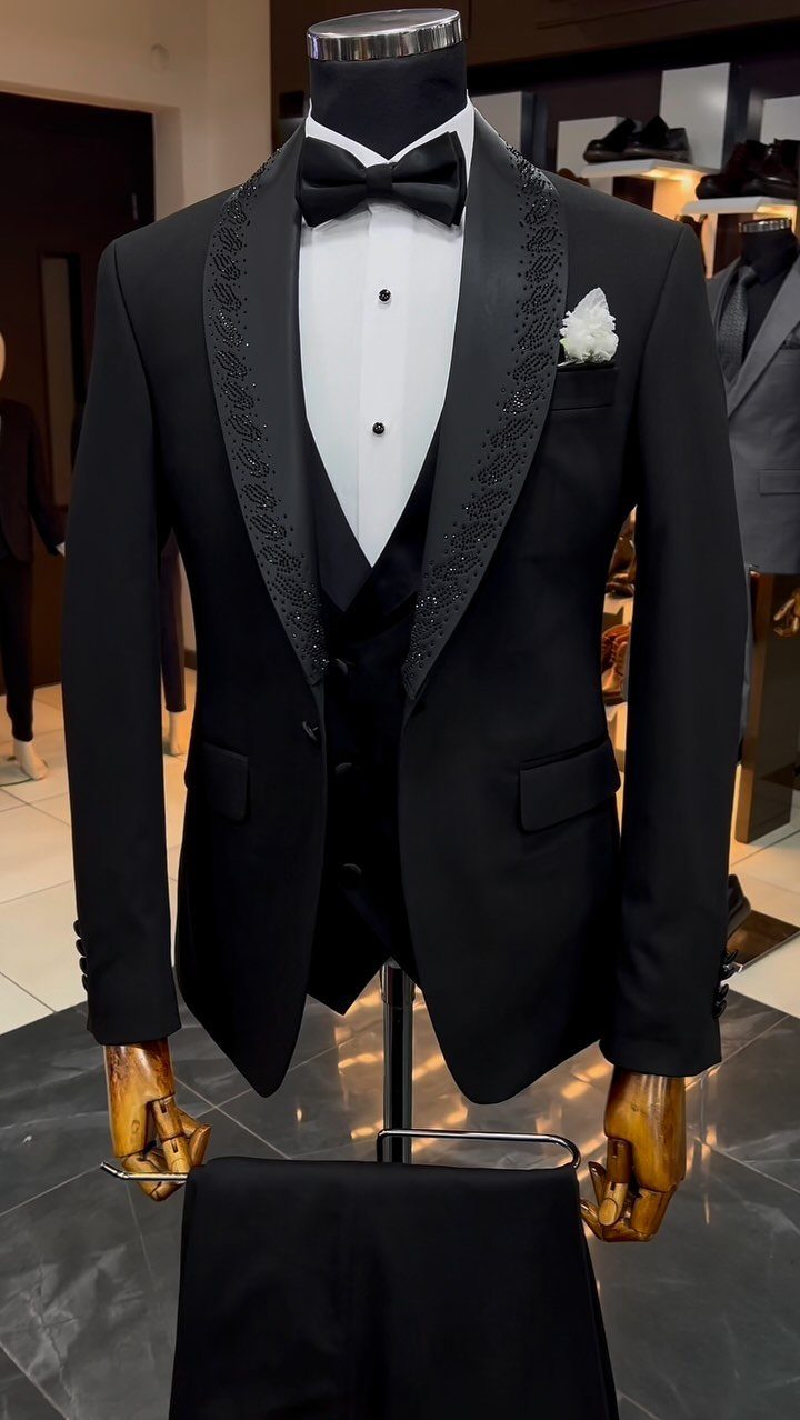 Black tuxedo on a mannequin featuring a white shirt and a black bow tie.