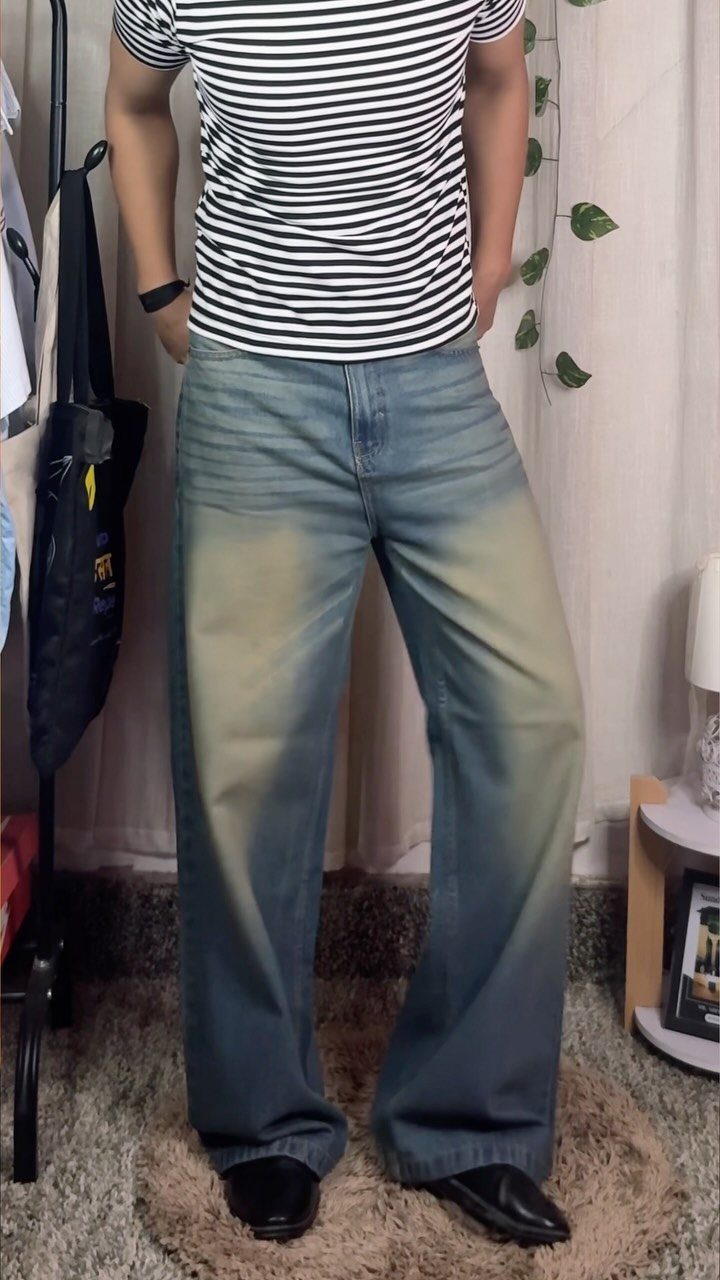 Person wearing striped t-shirt and light blue wide leg denim pants.