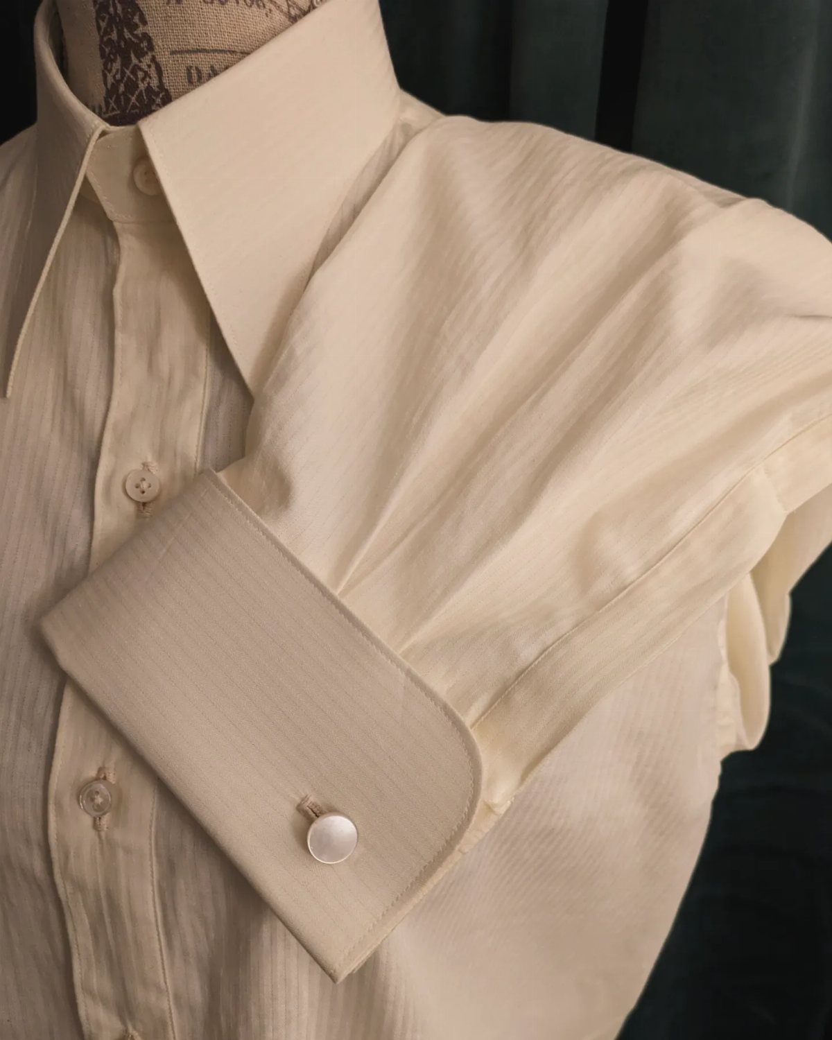 Cream vintage dress shirt with a stiff collar and wide cuffs on a mannequin.